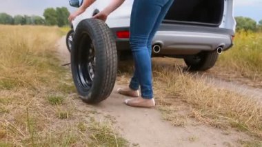 Genç kadın araba stepne kırsal dosyalanmış yükseltmelerdeki