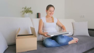 Mutlu genç kadın alışveriş online ve/açma parsel yeni giysiler ile