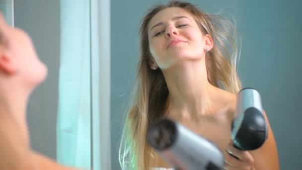 Zeitlupenaufnahmen einer schönen Frau, die im Hotelbadezimmer Haare am Spiegel trocknet — Stockvideo
