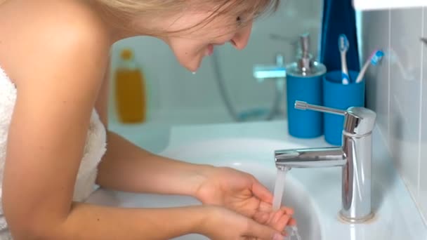 Closeup slow-motion beelden van jonge vrouw wassen gezicht lachend op ochtend — Stockvideo