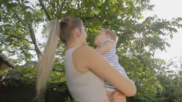Jovem feliz beijando e abraçando seu filho bebê de 1 ano — Vídeo de Stock