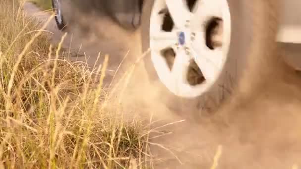 Primer plano de SUV a caballo rápido en el camino de tierra en el campo — Vídeos de Stock