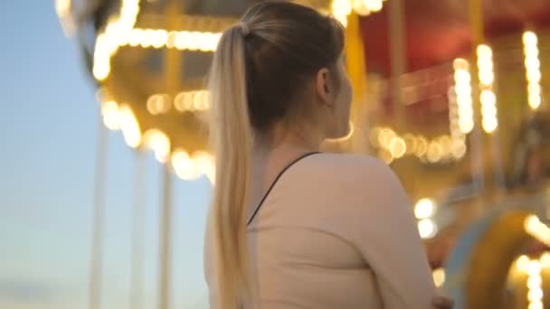 Mooie jonge vrouw op beurs op grote retro carrousel — Stockvideo