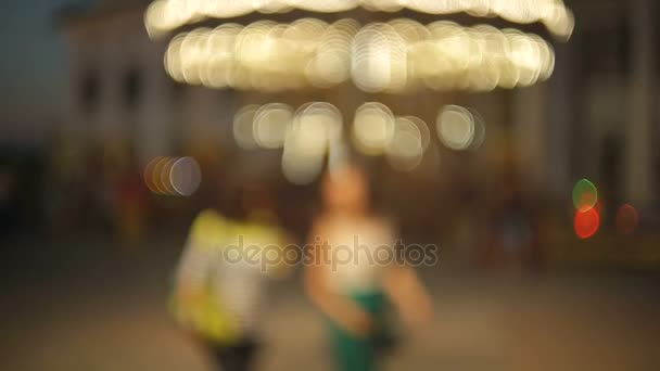 Ze zaměření pozadí s osvětlené rotující kolotoč carousel v zábavním parku — Stock video