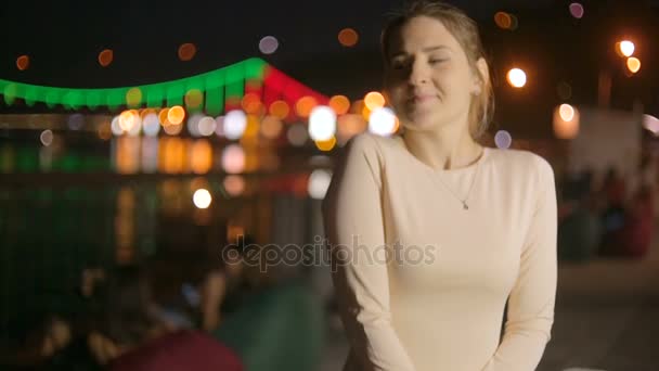 Schnappschuss einer eleganten jungen Frau, die nachts am Fluss auf ihren Freund wartet — Stockvideo
