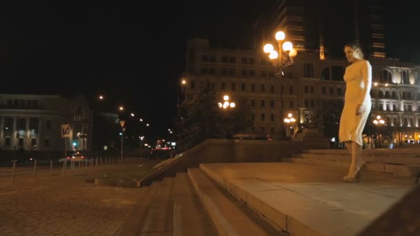 Sexy mujer joven en vestido y tacones altos caminando en la calle por la noche — Vídeos de Stock