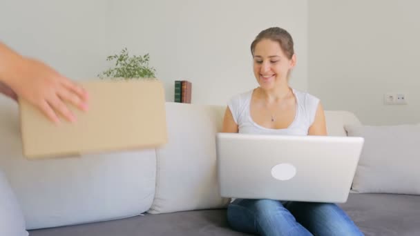 Glückliche junge Frau bestellt online Kleidung und erhält sofort Paket — Stockvideo