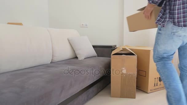 Young couple moving in the new house and carrying carton boxes — Stock Video