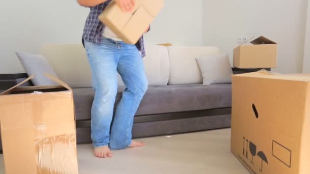 Pareja joven descansando en el sofá después de mudarse a su nueva casa — Vídeo de stock