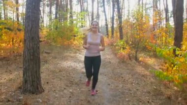 güneşli bir gün ormanda çalışan güzel gülümseyen kadın 4 k görüntüleri