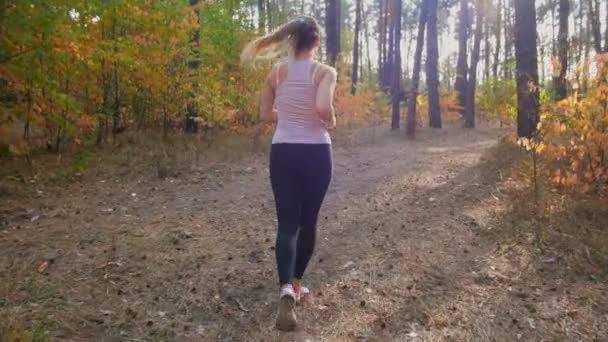 Filmato al rallentatore di una giovane donna sexy che corre tra i pini nella foresta — Video Stock