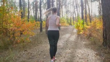 Ağır çekim Park'ta jogging ve tepeye çalışan genç ince kadın