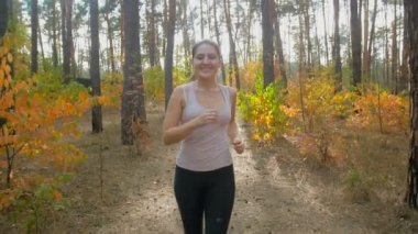 Ağır çekim portre çekim sonbahar ormanı koşu mutlu gülümseyen kadın