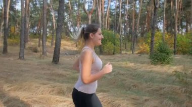 Yavaş çekim güzel gülümseyen kadın ormanda erken sabah saat çalışan