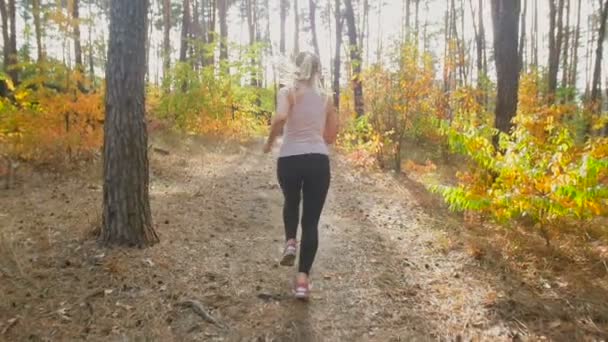太陽に向かって森で走っている陽気な女性のスローモーション映像 — ストック動画