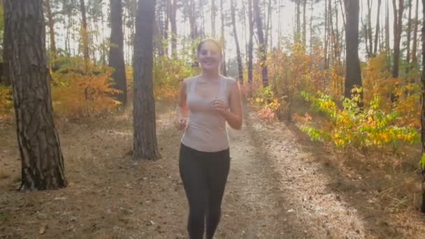 Zeitlupe Nahaufnahme einer jungen aktiven Frau mit Pferdeschwanz beim Training im Herbstwald — Stockvideo