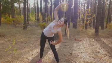 Dolly atış koşu önce ormanı stretching genç aktif kadın