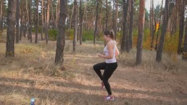 Orman çalıştırmadan önce ısınma genç ince kadın ağır çekim görüntüleri