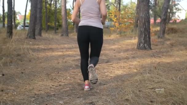Närbild slowmotion skott av sexig kvinna i leggings kör på forest — Stockvideo