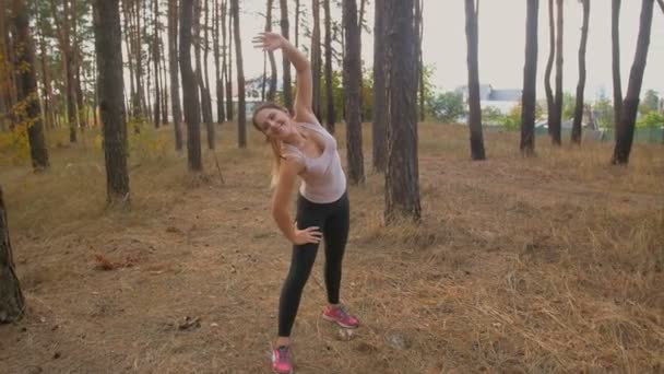 Plan au ralenti de la femme s'étirant avant le jogging à la forêt — Video