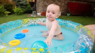 Şişme havuz bahçesinde oynayan aktif neşeli bebek çocuk