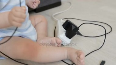 Kablolar ve elektrik uzatma kablolarını oynayan erkek bebek portre. Çocuk tehlikede kavramı