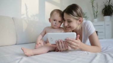 Şirin bebek çocuk annesi oturma odasında kanepede ile dijital tablet kullanma