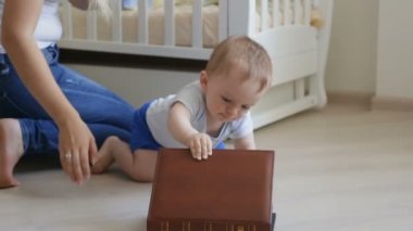 Yerde sürünen ve büyük kitap açmaya çalışırken şirin Bebek karyolası