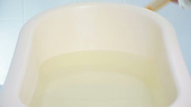 Bebeğin banyosunda su sıcaklığını kontrol etmek için termometre kullanan kadının Closeup 4k görüntüleri