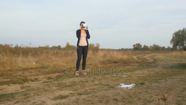 Mujer joven usando auriculares de visión en primera persona para operar el vuelo con drones — Vídeos de Stock