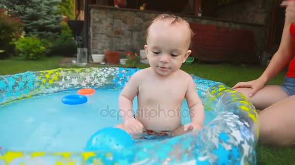 Feliz niño divirtiéndose en la piscina en el jardín — Vídeos de Stock