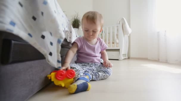 Милый мальчик играет на полу в спальне — стоковое видео