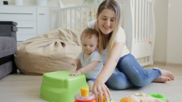 Roztomilý chlapeček hraje na buben, zatímco sedí na podlaze s jeho matkou — Stock video