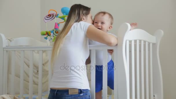 Cute toddler boy laughing being tickled by his mother in the crib — Stock Video