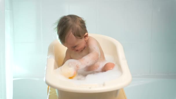 Slow motion beelden van leuke vrolijke baby spelen in de badkamer — Stockvideo