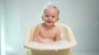 Sabun köpüğü ile banyo keyfi neşeli gülen bebek çocuk ağır çekim görüntüleri