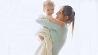 Mutlu genç anne bebek oğlu pencerede sarılma ağır çekim görüntüleri