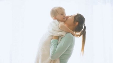 Mutlu gülümseyen anne bebek oğlu büyük pencerede kadar yükselterek ağır çekim görüntüleri