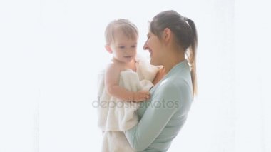 Mutlu neşeli genç anne bebek oğlu ile büyük pencere ayakta ağır çekim görüntüleri