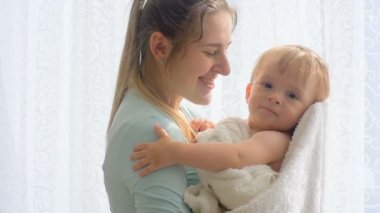 Ağır çekim portre video bir güneşli sabah bebek oğlu sarılma anne