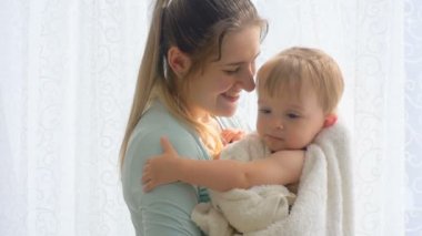 Ağır çekim portre çekim mutlu anne bebeğini banyo yaptıktan sonra sarılma