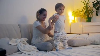 Geceleri uykusuz yürümeye başlayan çocuk anne yatakta ile gülümseyen