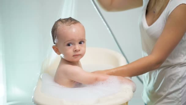 Slow motion beelden van moeder wassen van shampoo van het hoofdje van de baby — Stockvideo