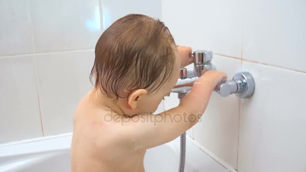 4 k beelden van schattige baby spelen met waterkraan in de badkamer — Stockvideo