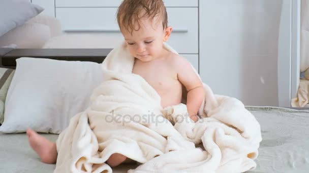 4K видео милого мальчика, сидящего с одеялом на кровати — стоковое видео