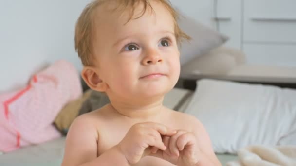 4 k film av söt glad baby pojke sitter på sängen — Stockvideo