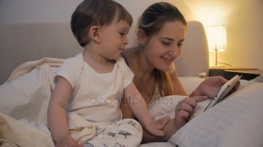 4 k film tablet bilgisayarla yatağa gece bebek ile anne