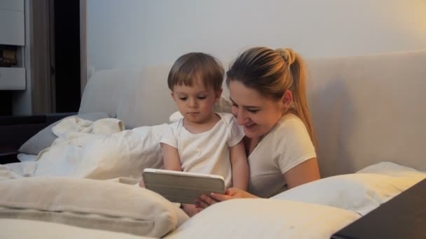 4k imagens de criança menino assistindo desenhos animados antes de ir dormir — Vídeo de Stock