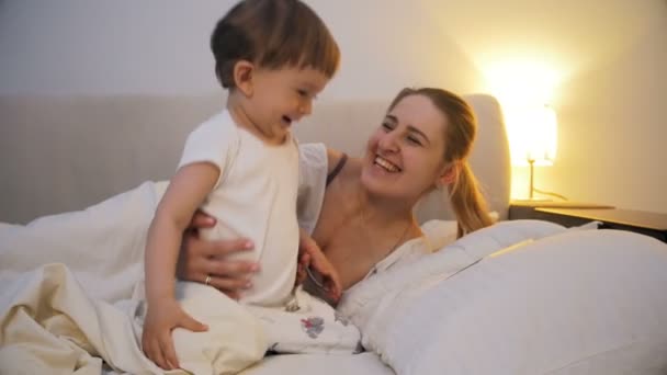 Lindo niño pequeño viendo vídeo en la tableta antes de ir a dormir — Vídeos de Stock