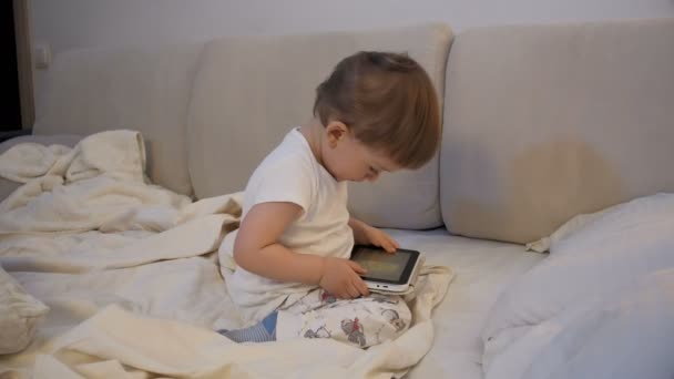 Menino bonito da criança usando tablet computador na cama antes de ir dormir — Vídeo de Stock